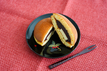 黒皿に置かれた半分のどら焼きとフォーク