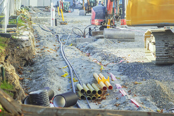 Construction site in progress with pipes, excavator, and marked cables. Reflects engineering precision, labor process, city growth, sustainable infrastructure, and evolution of modern metropolitans.