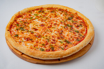 A whole pizza is shown, covered in melted cheese and pesto