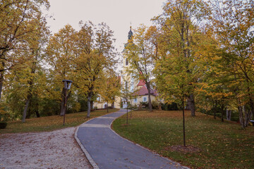 Park path leading to a church in autumn season