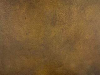 Close up of antique gold metallic washed decorative paint. Dark gold limestone washed textured paint, with abstract grunge and dirt pattern. Seamless background texture.