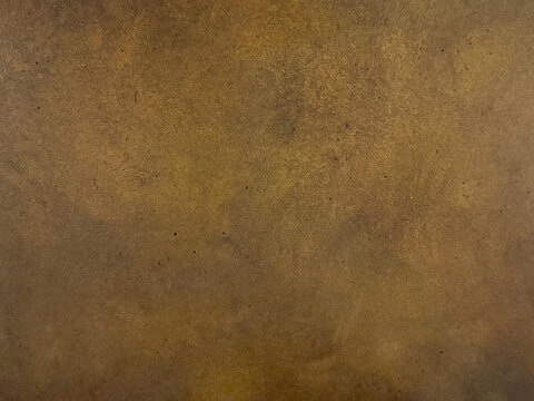 Close up of antique gold metallic washed decorative paint. Dark gold limestone washed textured paint, with abstract grunge and dirt pattern. Seamless background texture.