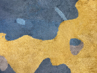 Random design with abstract pattern hand tufted carpet texture, in blue, yellow, brown, red, and white color. Random colorful pattern carpet rug seamless background texture