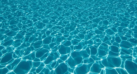 Obraz premium A closeup view of rippling turquoise water with sunlight reflecting in a network of shimmering patterns