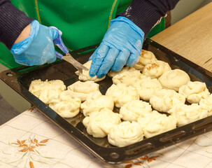 A person is cutting dough into small pieces
