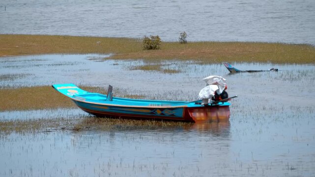 Colorful traditional Khmer style boat are parked in the reeds near the shore in West Baray water reservoir in Siem Reap, Cambodia