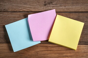 Three colorful sticky notes on a wooden surface (1)