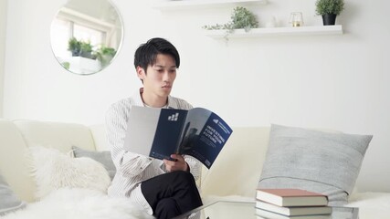 投資について考えるアジア人男性 - Powered by Adobe