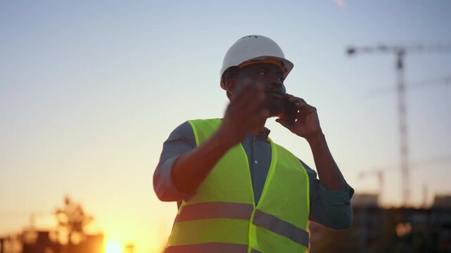 Modern boss of construction site taking by phone emotionally, decide of problems . Professional foreman working at construction site, modern technology and innovation in building, city development