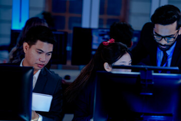 Deep dive into the code  Software engineers review system architecture or debug complex scripts together. Analyzing performance metrics on multiple screens in a dev hub at night.