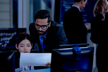 Critical AI model review. Senior data scientist leans over analyzing code output with junior engineers. Debugging complex algorithms together for optimal service performance at night.