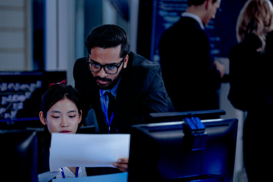 Critical AI model review. Senior data scientist leans over analyzing code output with junior engineers. Debugging complex algorithms together for optimal service performance at night. - Powered by Adobe