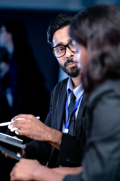 Future AI strategy talk. Male visionary leader explains ethical AI implementation or market disruption plan to female strategist surrounded by futuristic data screens.