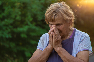 An elderly woman prays in the garden. selective focus.