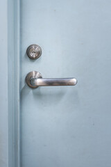 Close-up at handle of service room's metal door that closed. Selective focus at door handle part.