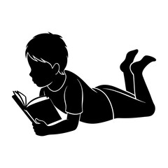 Silhouette of a young boy lying down and reading a book