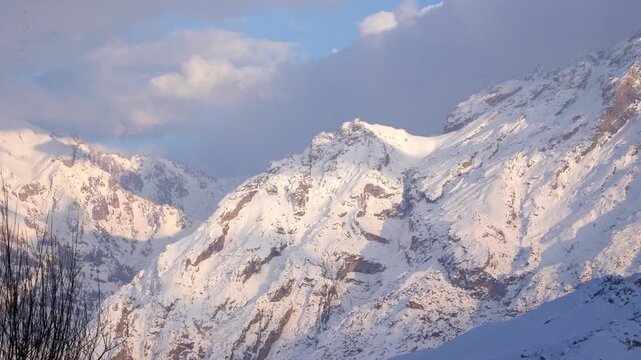 Cinematic view of snowy Mount Sumbul in Hakkari at sunset, majestic snow-capped mountain peaks under blue sky with clouds, winter landscape in Eastern Turkey, 4K 25fps. 3
