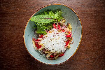 Vibrant salad with fresh veggies, herbs, and cheese on a rustic table