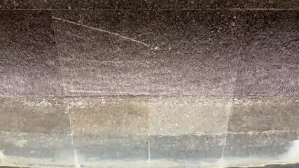 4k footage, close up cascading waterfall fountain on a slate stone. Seen here the water fountain droplets dropping, landscape garden design. Contemporary modern garden design waterfall.