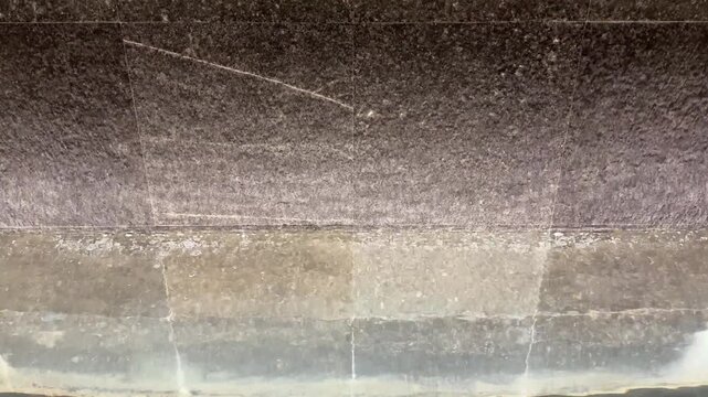 4k footage, close up cascading waterfall fountain on a slate stone. Seen here the water fountain droplets dropping, landscape garden design. Contemporary modern garden design waterfall.