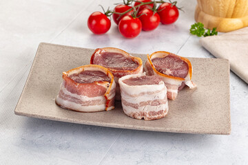 Raw pork tenferloin with bacon