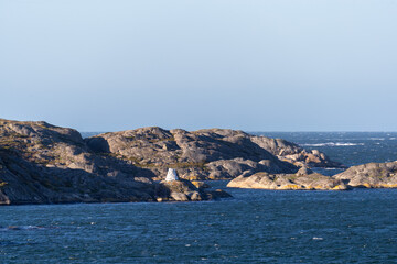 Rocky coastline on sunny day with open sea background