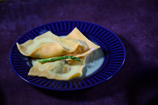 Large cornmeal dough ravioli with seafood on plate. Handmade work. - Powered by Adobe