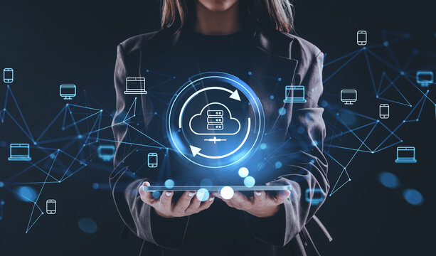 Woman holding tablet with glowing cloud storage hologram and connected devices representing online data network and internet backup concept.