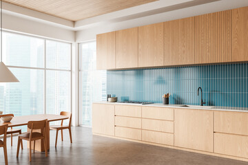 Modern kitchen interior design with wooden cabinets, blue tiled backsplash, and large windows with city view in minimal Scandinavian style. 3D Rendering