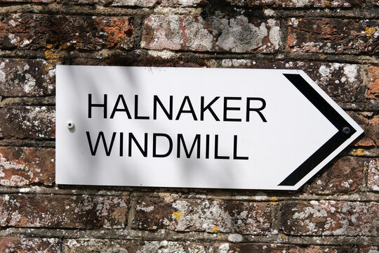 Sign on the wall pointing to Halnaker Windmill. Boxgrove, West Sussex, England. 