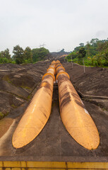 Giant penstock pipes at the Saguling Hydroelectric Power Plant in West Java, Indonesia. These massive pipes channel water to turbines, generating renewable energy.