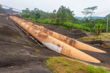 Giant penstock pipes at the Saguling Hydroelectric Power Plant in West Java, Indonesia. These massive pipes channel water to turbines, generating renewable energy.
