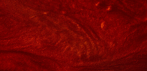 Shimmering red abstract background. Liquid glitter paint texture waves and swirls. Beautiful shiny...