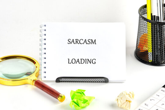 A quirky desk scene features a notebook declaring sarcasm loading, complemented by colorful paper balls, a magnifying glass, and vibrant stationery for a playful atmosphere