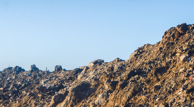 Challenging construction site with earthy terrain and clear sky evokes resilience, representing industry infrastructure and hard work in challenging conditions