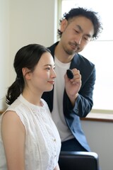 女性にメイクアップをする日本人男性