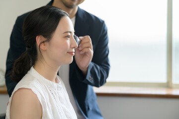 女性にメイクアップをする日本人男性