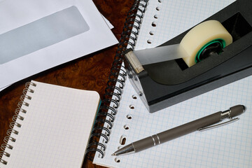 office envelope, spiral notebook, adhesive tape and ballpoint pens