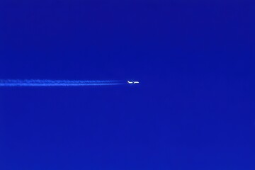 Jet soaring through expansive blue sky leaving a trail of vapor in its wake representing modern travel innovation and the essence of airborne connectivity captured with clarity