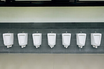 A row of clean male urinals installed outdoors