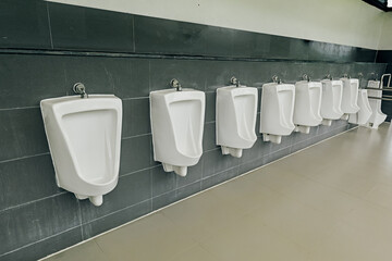 A row of clean male urinals installed outdoors