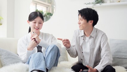 スマホが原因で口論をするアジア人カップル