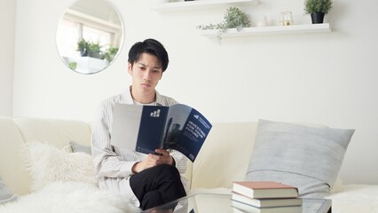 投資について考えるアジア人男性