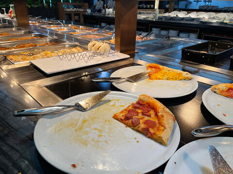 Buffet de lujo, grande y espacioso con ricos y apetecibles platos fr&iacute;os y calientes de comida como porci&oacute;n de pizza reci&eacute;n hecha con esp&aacute;tula servidor met&aacute;lica