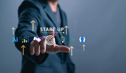 Businessman pointing at virtual startup interface with icons representing innovation, AI, teamwork, data analytics, goal setting and business growth strategy in modern technology
