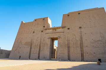 The famous egyptian temple of Edfu, Egypt, dedicated to the god Horus, with its facade and entrance pylon. Blue sky on the background.