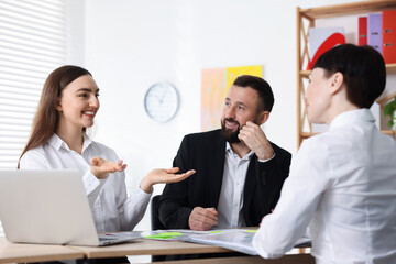 Business process. Colleagues working together at desk in office