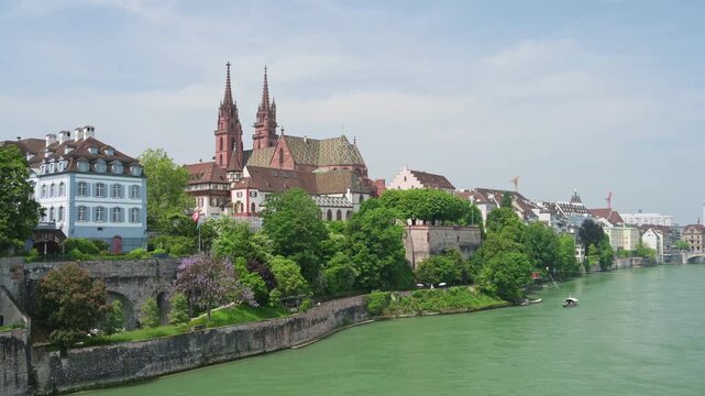 Basel, Switzerland &mdash; Scenic summer view of the Basel Cathedral (Basler M&uuml;nster) and historic old town from the Rhine riverbank