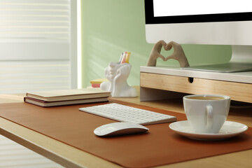 Stylish workplace with computer and brown mat on desk in office, closeup