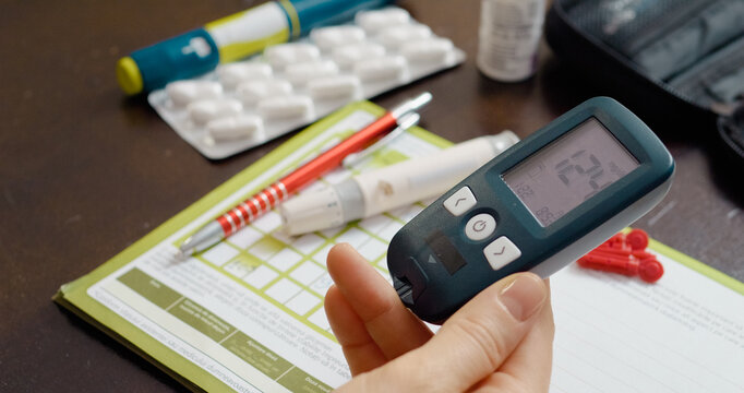 A woman conducts a glucose test at home, revealing a high blood sugar level close to diabetes. She uses a glucometer to monitor her health for better management.